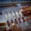 a school of pharmacy student holding a package of syringes in a lab
